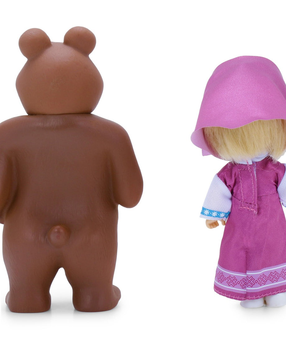 Brown bear figurine and a doll in a pink dress with a hood on a white background